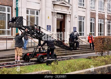 Location filming of Alex Rider story, cameraman on crane platform, crew taking outdoor shoot at Brookland Secondary School for Amazon Prime Stock Photo