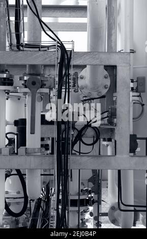 industrial background with pipes, joints, bolts, valves and electrical wires, black and white photo Stock Photo