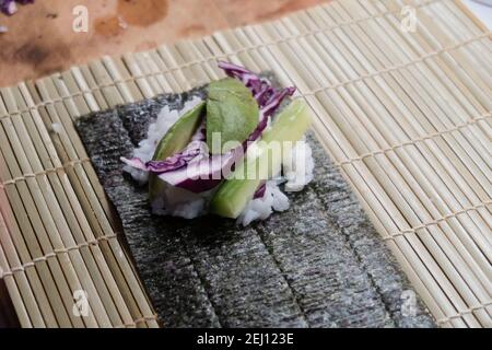 Woman using bamboo rolling mat for home made sushi Stock Photo - Alamy