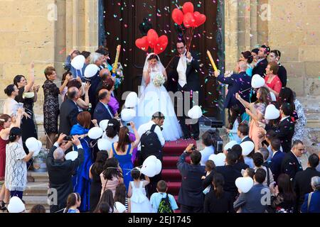 Newly weds celebrating the occasion with family and friends whilst leaving the St. George's Basilica in Victoria (Gozo), Malta Stock Photo