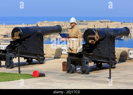 A gunner preparing to fire a SBBL 32-pounder gun at the Saluting Battery of the Upper Barrakka Gardens in Valletta, Malta Stock Photo