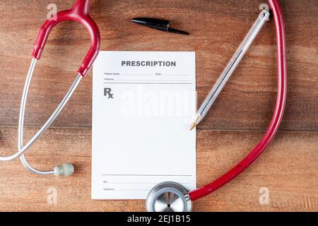 close up isolated flat lay image of a physician's desk where there is a pen, sthetoscope and a blank prescription which can be used as template to add Stock Photo