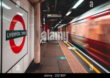 London UK January 2021 Sign of the Liverpool Street underground tube metro station, train in motion blurred. Platforms empty during UKs national covid Stock Photo