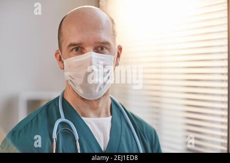 Front view portrait of mature male veterinarian wearing mask and looking at camera in vet clinic, copy space Stock Photo