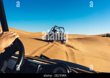 View of steering wheel and desert landscape from driver seat during safari extreme off road tour on quad buggy bikes Stock Photo