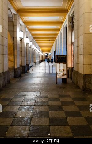 Wroclaw February 10 2020 Long arcades tunnel with walking people at night Stock Photo