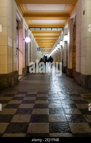 Wroclaw February 10 2020 Long arcades tunnel with walking people at night Stock Photo