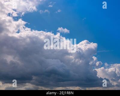 Massive rain clouds - Cumulus congestus - creates a wall of clouds in the blue sky. Stock Photo