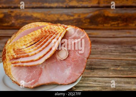 Delicious honey smoked pork ham on rustic wooden background. Stock Photo