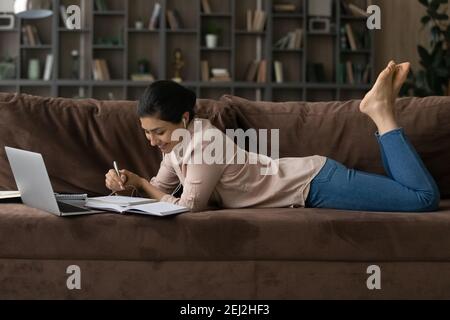 Happy millennial female study distant on computer at home Stock Photo