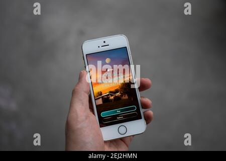 A man plays the new augmented reality game "For All Mankind: Time Capsule" on his iPhone. The AR experience is based on the Apple TV+ space drama. Stock Photo