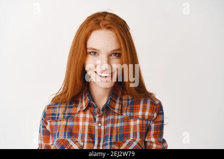 attractive, flirty girl looking at camera while touching hair isolated on  grey Stock Photo - Alamy