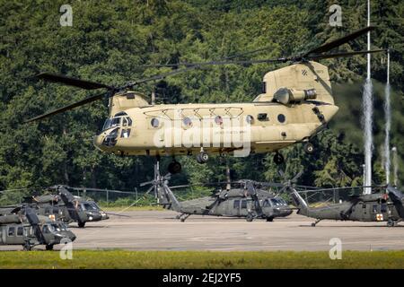 US Army Boeing CH-47F Chinook transport helicopter taking off with UH-60 Blackhawk helicopters in the background. The Netherlands - July 2, 2020 Stock Photo
