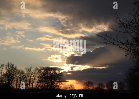 A beautyful sunset with cloudy sky and trees in the background Stock Photo