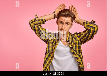 Man with hands like rabbit ears, pink background Stock Photo