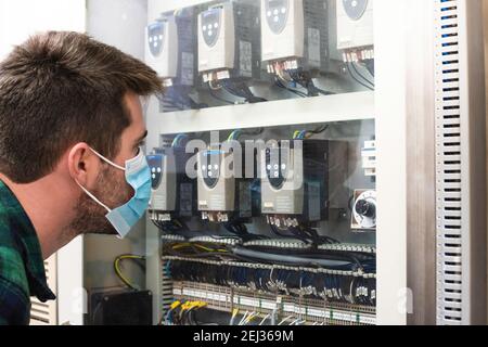 Young engineer doing the maintenance of a control panel Stock Photo