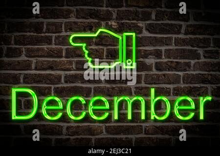 Detail photo of a neon sign on a wall with the inscription December Stock Photo