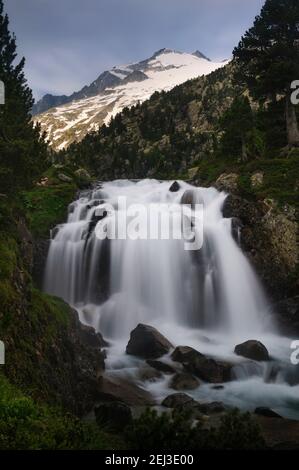 Plan and Forau d'Aigualluts (meadow and waterfall) under the Aneto summit in summer (Benasque, Pyrenees, Spain) Stock Photo