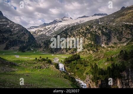 Plan and Forau d'Aigualluts (meadow and waterfall) under the Aneto summit in summer (Benasque, Pyrenees, Spain) Stock Photo