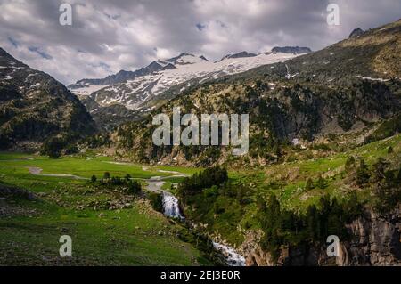 Plan and Forau d'Aigualluts (meadow and waterfall) under the Aneto summit in summer (Benasque, Pyrenees, Spain) Stock Photo