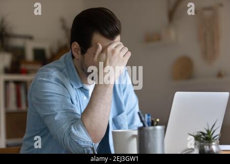 Unhappy man work on laptop having problems Stock Photo