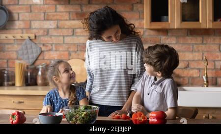 Happy mother with little son and daughter cooking together Stock Photo