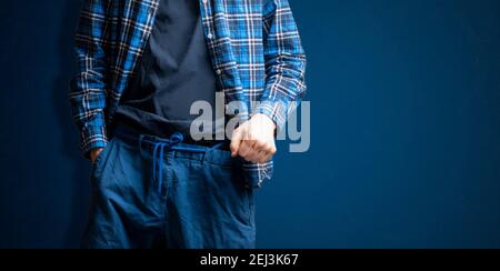 young male hipster tight the shoelace belt,trendy fashion idea isolated against the wall Stock Photo