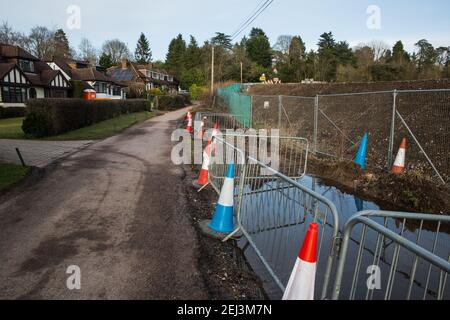 Chalfont St Giles, UK. 20th February, 2021. A raised temporary haul road is being prepared alongside Bottom House Farm Lane for use in the construction of a ventilation shaft for the Chiltern Tunnel on the HS2 high-speed rail link. Owners of the properties alongside Bottom House Farm Lane have been advised by HS2 that the lane will need to be raised to a similar level as the haul road in order to meet highway regulations, so blocking their previous view of the fields and River Misbourne beyond. Credit: Mark Kerrison/Alamy Live News Stock Photo