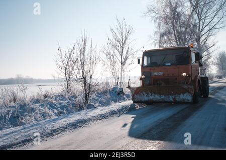 TYMOWA, POLAND - JANUARY 31, 2021. Truck with a plow clears the road from snow. Stock Photo