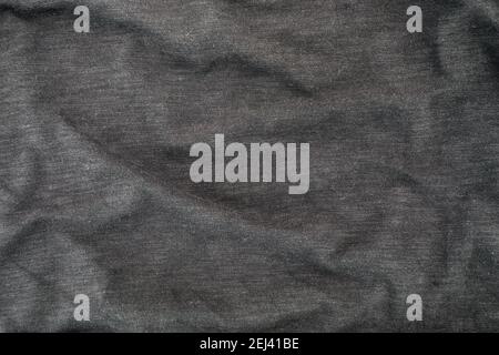 Dark grey cotton fabric texture. Clothes cotton t-shirt background with folds. Flat lay top view. Stock Photo