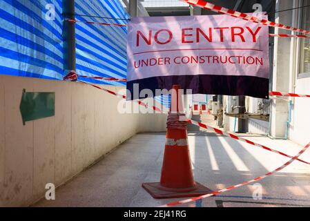 No entry sign hanging on the walkway in front of construction site Stock Photo