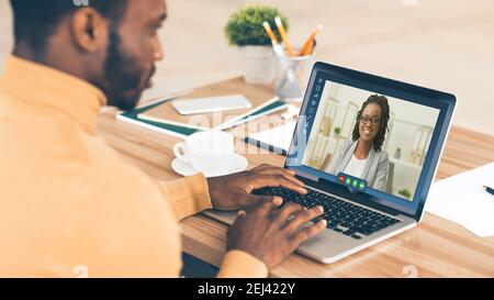 Online Meeting Concept. Black employee having video call conference with female colleague Stock Photo