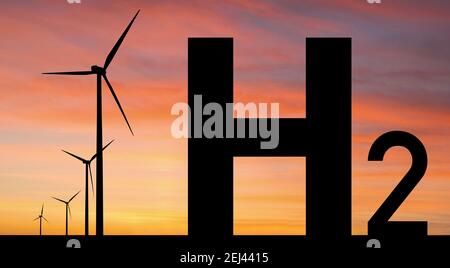 Silhouettes of Hydrogen symbol and wind turbines. Getting green hydrogen from renewable energy sources Stock Photo
