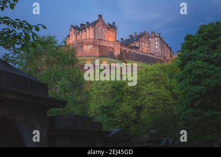 A spooky, moody view of the landmark Edinburgh Castle at night from St Cuthbert cemetery in Edinburgh, Scotland. Stock Photo