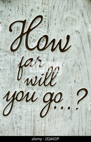 Rustic wooden sign with text: ' how far will you go ?'. Concept message in English Stock Photo