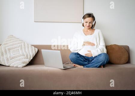 Pregnant woman video chatting with doctor on tablet. Professional medical online consultation concept Stock Photo