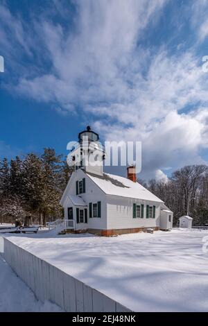 Very light snow falling on the 150 year old Old Mission Point Lighthouse with new shutters installed in 2020 that are representative of the shutters i Stock Photo