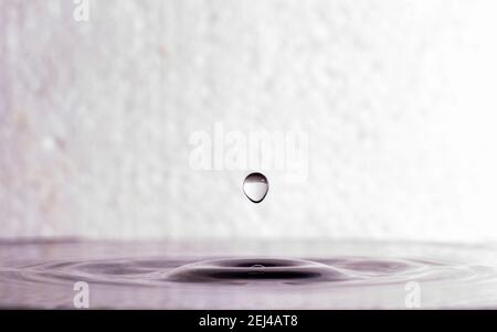 form of water droplets after falling on rippled water surface Stock Photo