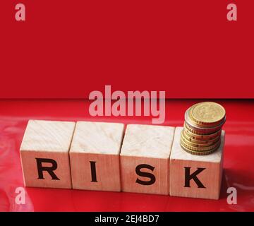 RISK word written on wooden cubes and coins. Financial risk assessment, risk reward and portfolio risk management business concept. Stock Photo