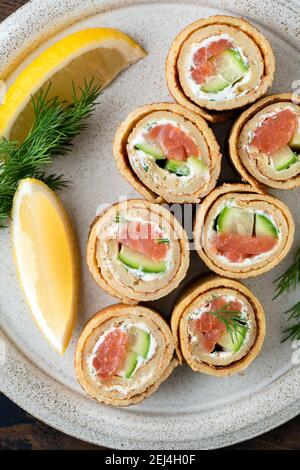 Crepe salmon rolls with cucumber and cream cheese. Appetizer food top view Stock Photo