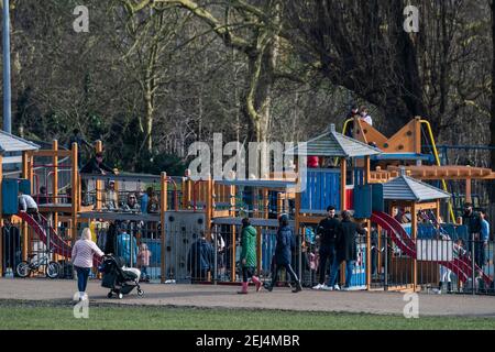 London, UK. 21st Feb, 2021. The playground is busy with children and parents mixing in close proximity - Crowds get exercise in Hampstead Heath as the first spring weather arrives, while London remains in lockdown 3. Credit: Guy Bell/Alamy Live News Stock Photo