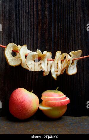 Dried apple slices, dried apple rings strung on string and apples, variety Gala Stock Photo