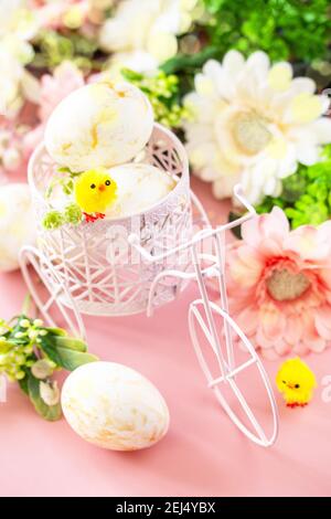 Easter floral background. Spring flowers gerbera with easter eggs on pink background. Stock Photo