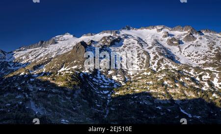 Maladeta Massif and the Aneto summit, the hightest peak in the Pyrenees, in a summer sunrise, seen from the path to the port of Benasque. (Spain) Stock Photo