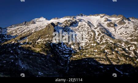 Maladeta Massif and the Aneto summit, the hightest peak in the Pyrenees, in a summer sunrise, seen from the path to the port of Benasque. (Spain) Stock Photo