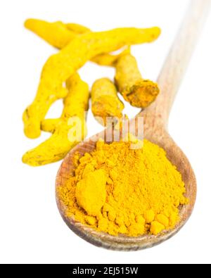 Turmeric roots and powder on wooden spoon Stock Photo