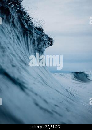 Perfect ocean waves with blue water cloudy sky. Stock Photo
