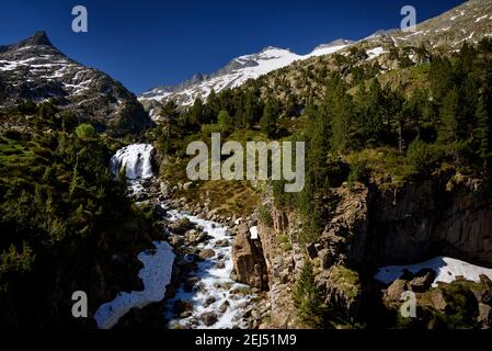 Plan and Forau d'Aigualluts (meadow and waterfall) under the Aneto summit in summer (Benasque, Pyrenees, Spain) Stock Photo