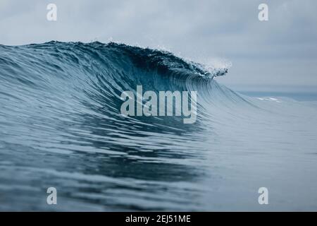 Perfect ocean waves with blue water cloudy sky. Stock Photo