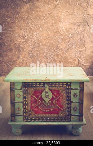 Stylish decorated old chest with beige background, brown wall with texture. Empty space for text, Vintyge style Stock Photo
